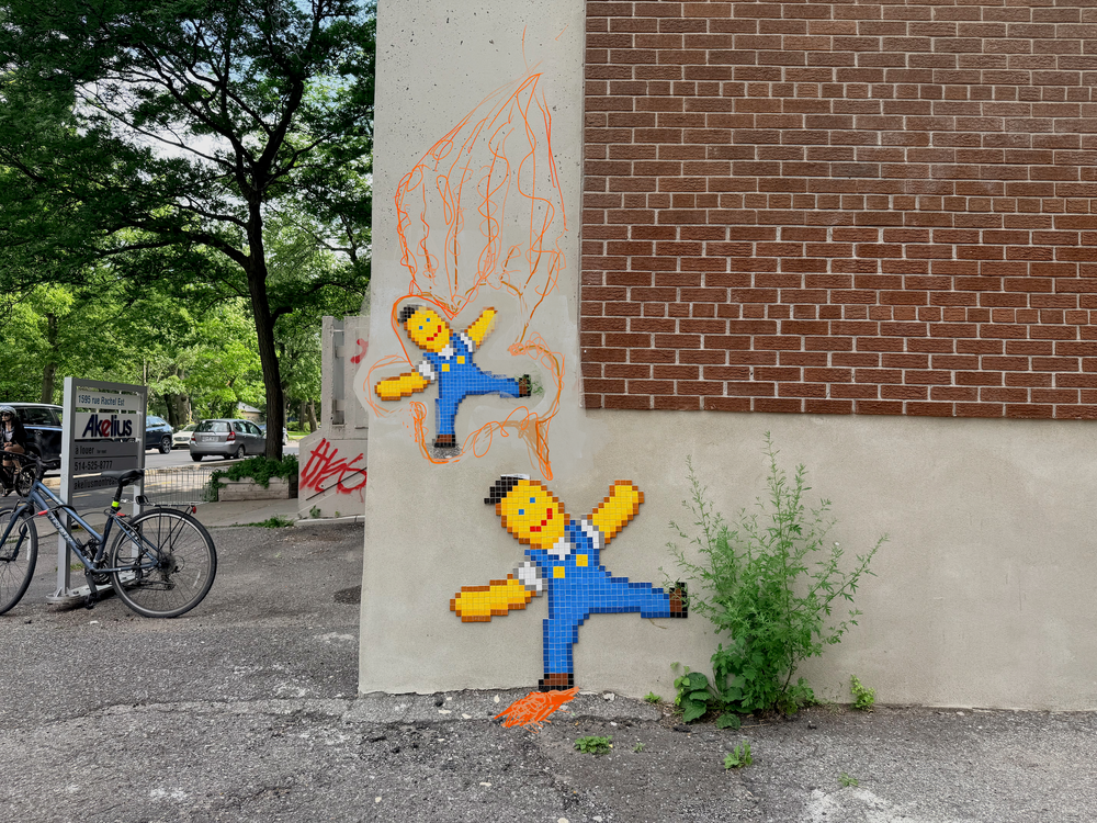 Photo of wall with two pixel worker men looking happy stuck to the wall with doodles