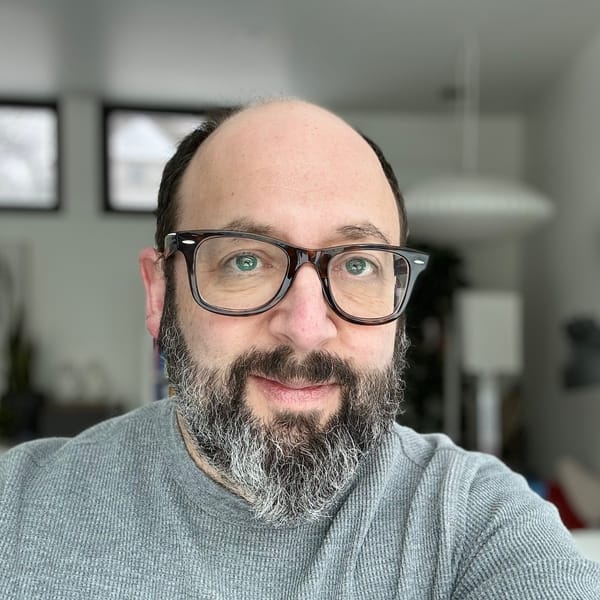 Andrew Boardman looking into camera — glasses, beard and smile